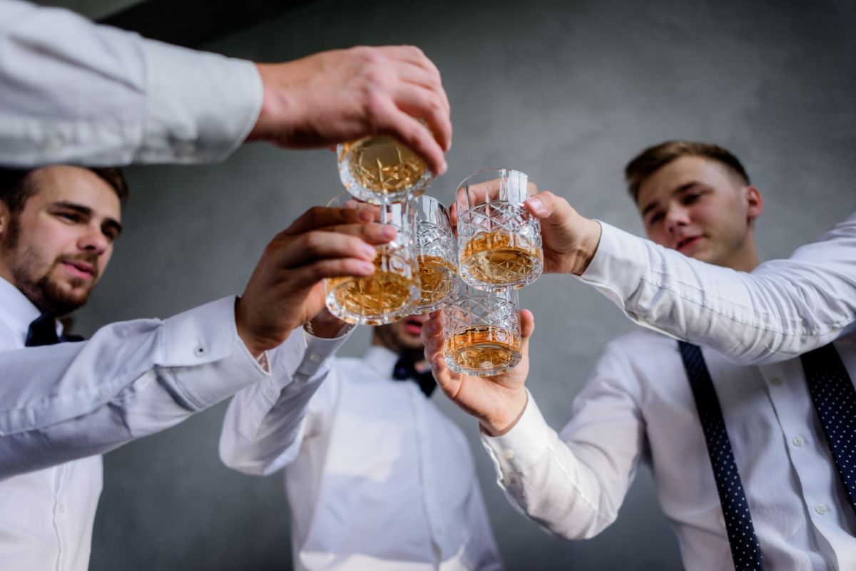 Grupka mężczyzn wznosząca toast podczas wieczoru kawalerskiego w Krakowie