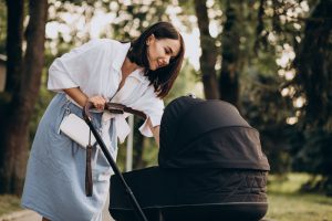 kobieta stojąca obok wózka dla dziecka
